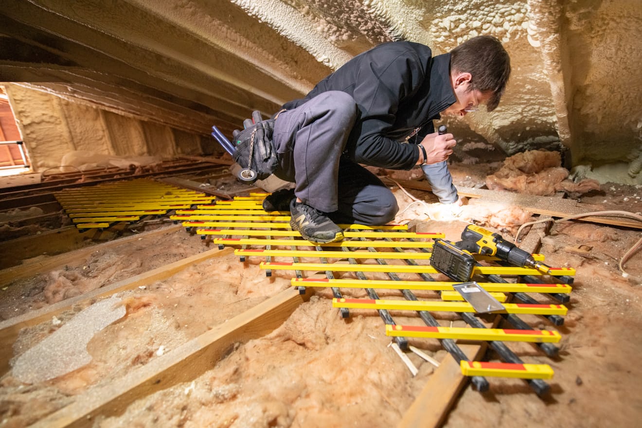 Technician inspecting the underside of a structure with a light during a rat inspection
